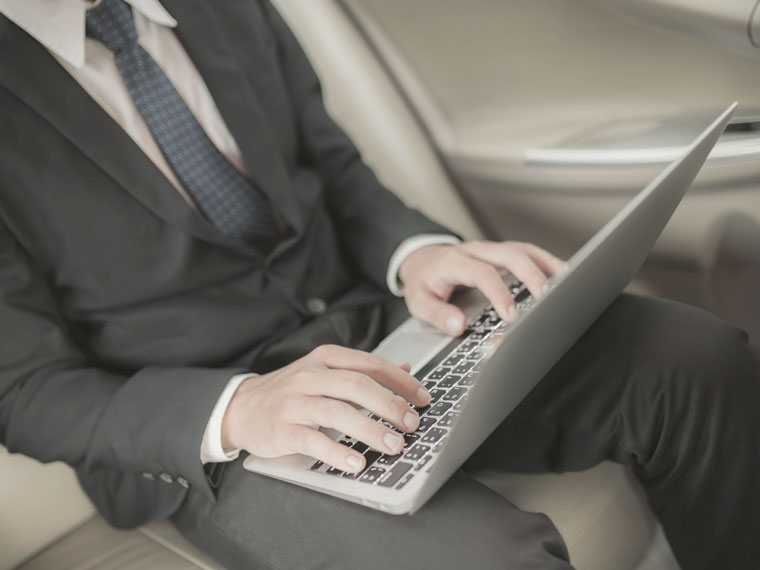 a man typing on a laptop in London provided by Addison Lee