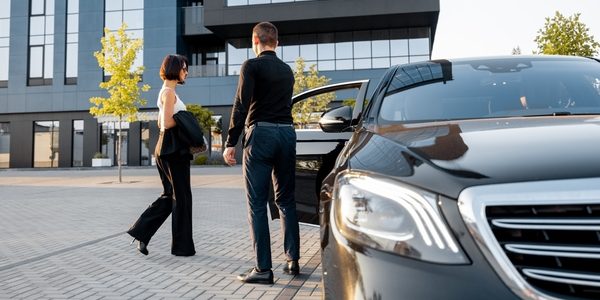 Car door being opened for a lady by Chauffeur